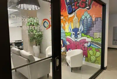 Proximity Learning team workspace with colorful mural wall art.