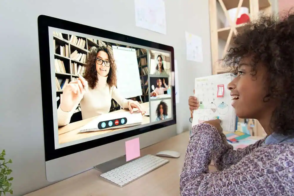 Student engaging in online learning with a teacher via video conference.