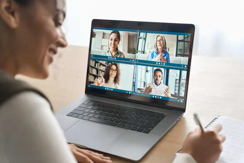 Online virtual classroom with diverse teachers on a laptop screen.