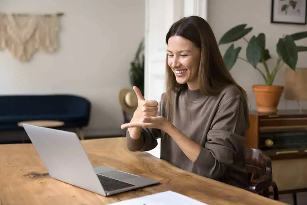 Woman smiling during online learning session with laptop at home.