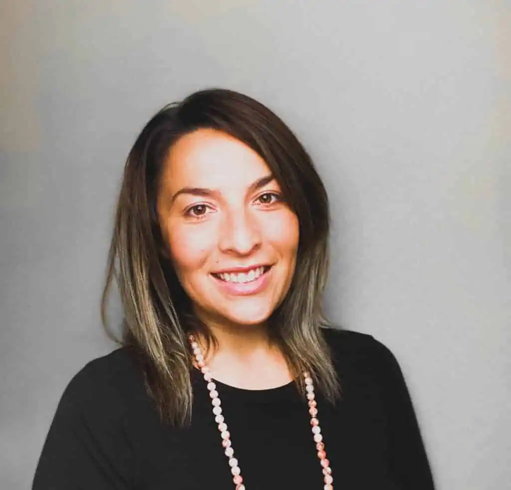 Woman smiling in professional attire, promoting online education and virtual learning.