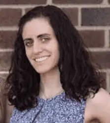 Female teacher conducting online class from home, smiling at camera.