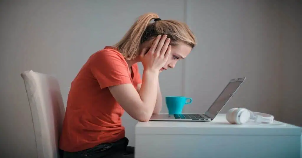 Student frustrated with online learning on laptop at home.