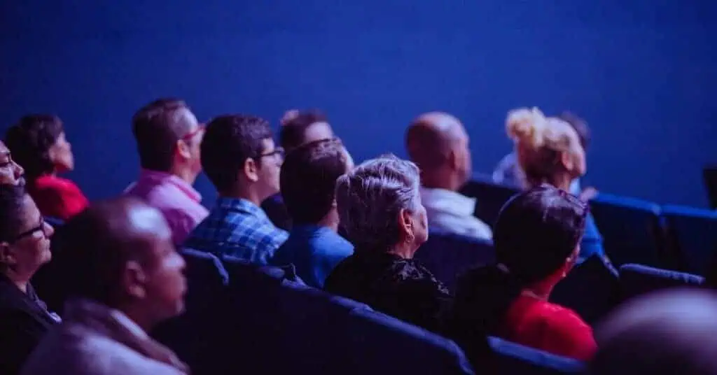 Audience attending a conference or seminar, listening attentively to a speaker.