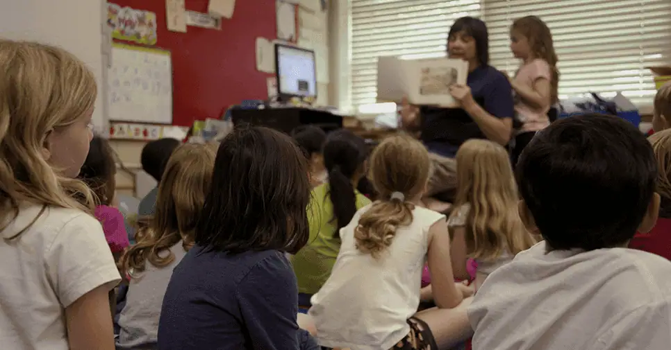 Engaged students in a classroom with a teacher using remote learning technology.