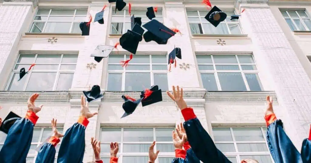 Graduates throw their hats into the air in celebration.