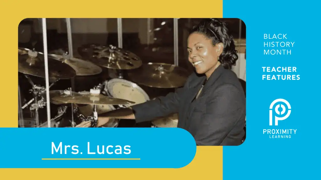 Mrs. Lucas teaching music online with drum set, engaging students remotely.