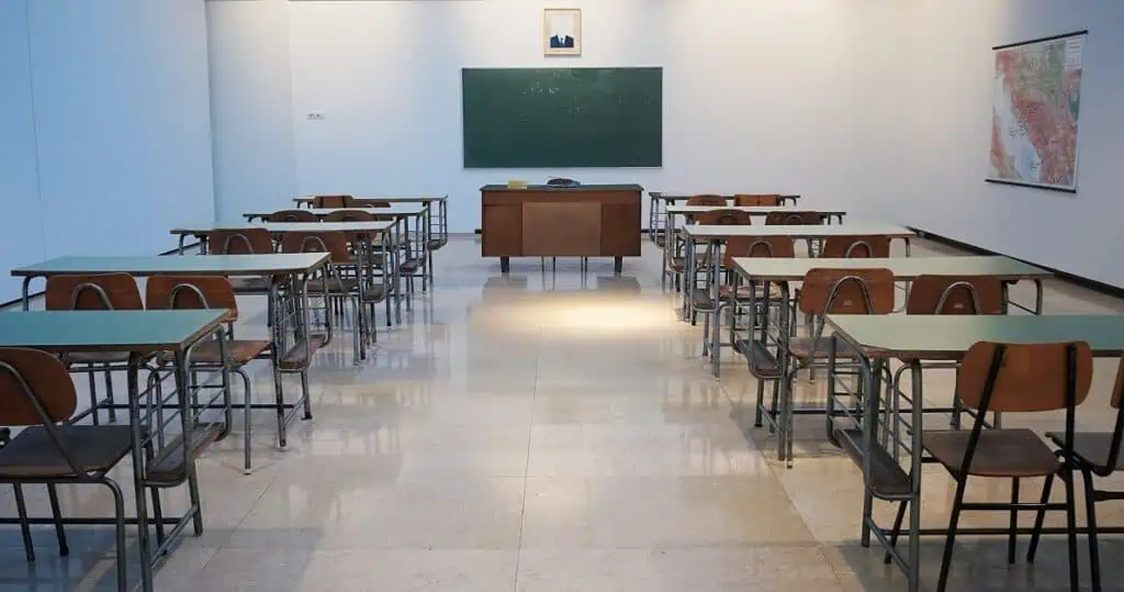 Proximity Learning virtual classroom setup with desks and blackboard.