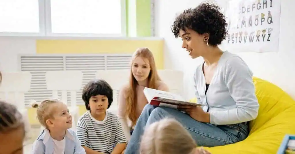 Engaged teacher reading to diverse students in a classroom setting.