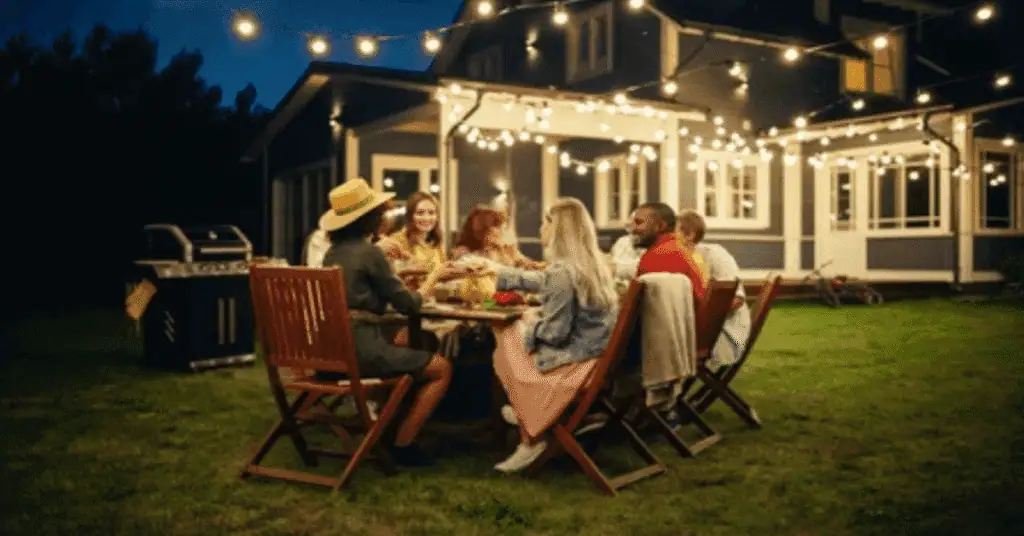 Outdoor evening gathering with friends under string lights.