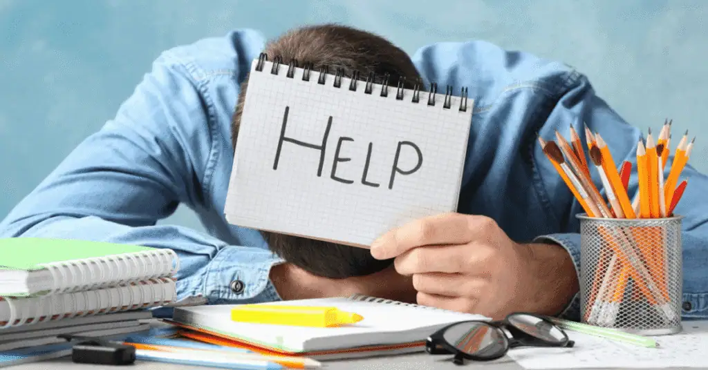 Student holding a "Help" sign at a desk with school supplies, representing online learning support.