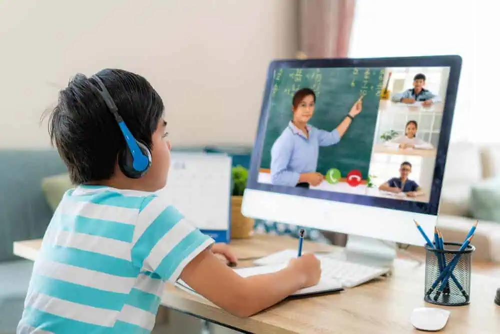 A young boy student taking a synchronous small group online class.