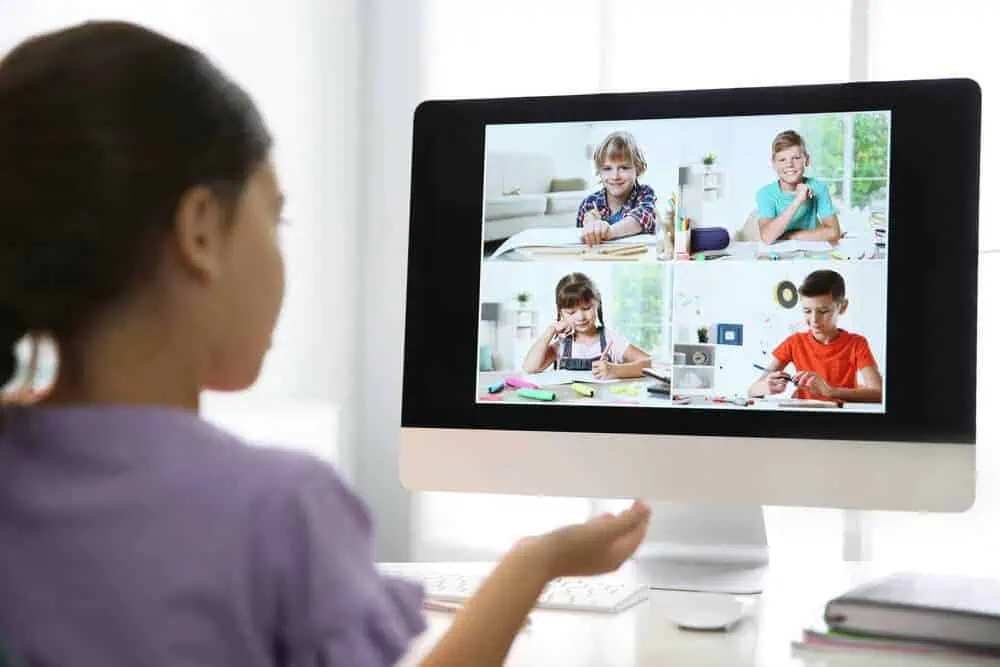 Children participating in a virtual classroom session via computer for remote learning.