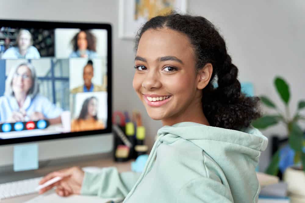 Student participating in a virtual classroom session via computer.