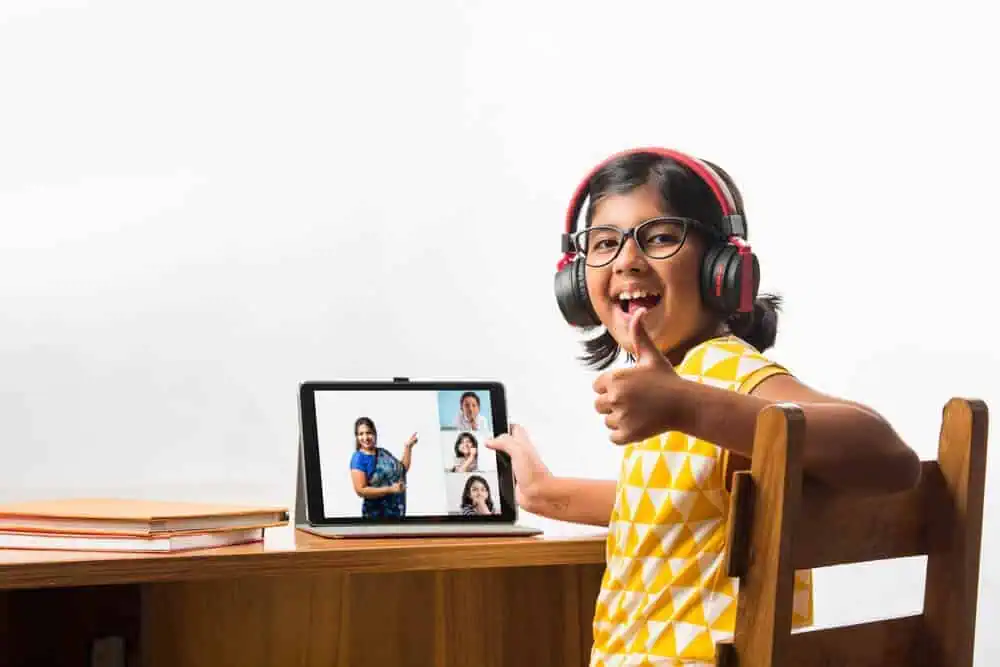 Student taking virtual livestream class in school classroom.