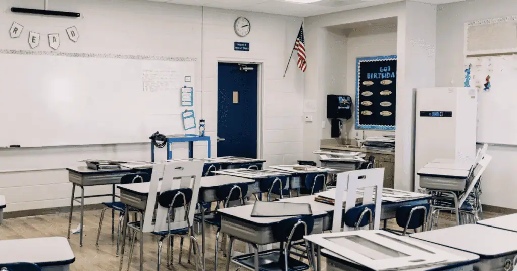 classroom with empty desk facing a whiteboard