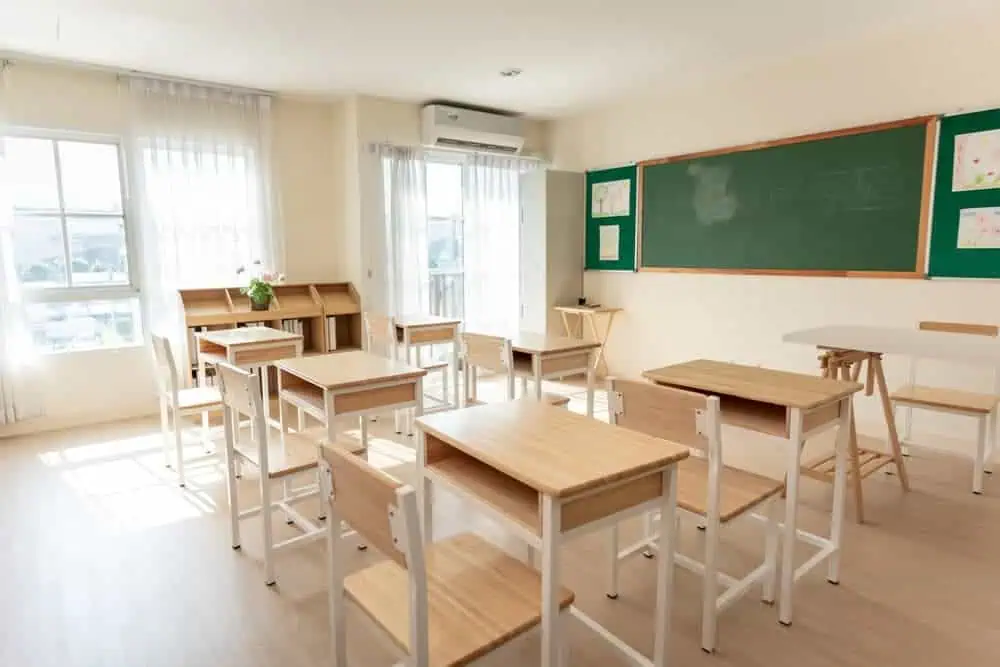 A shot of a small empty classroom with chairs under desks in elementary