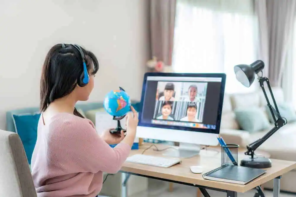 A livestreamed teacher teaching geography to a small group of students on a computer