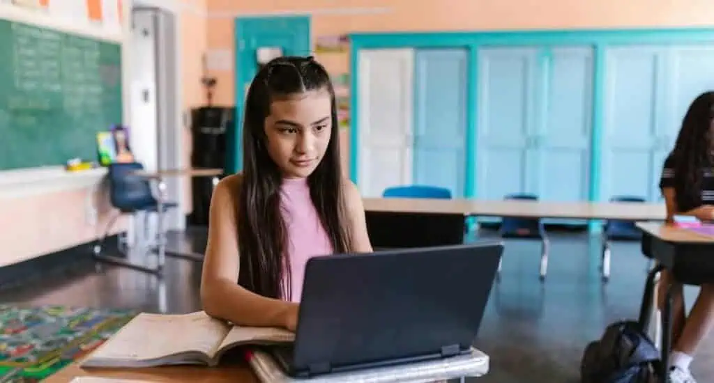 A young girl sits at her desk