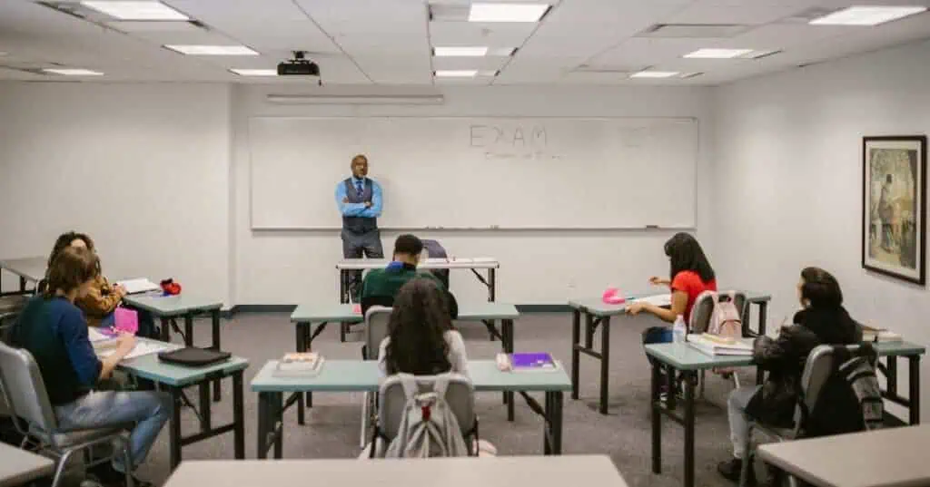 A teacher stands at the front of the classroom