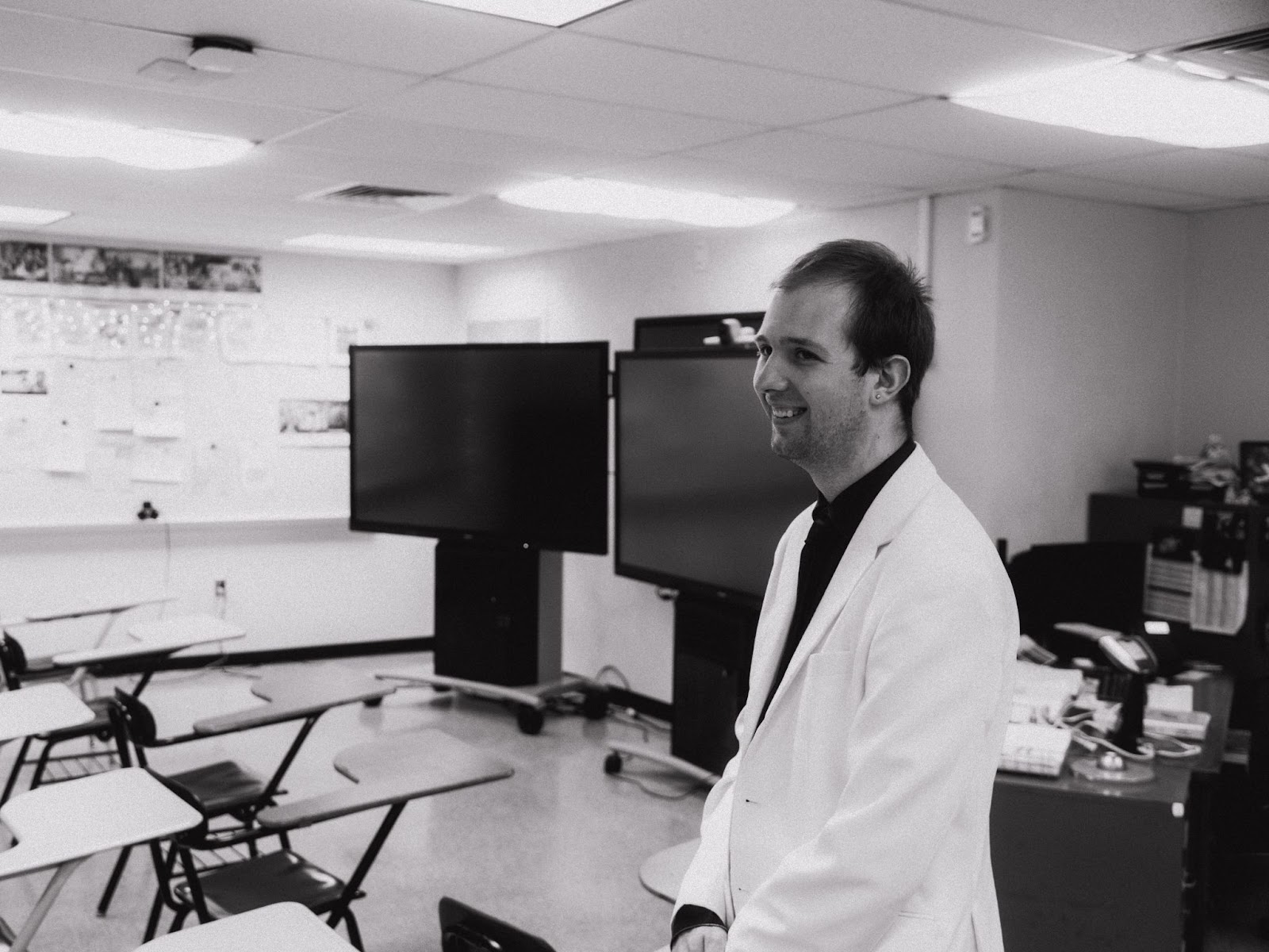 teacher looks out at empty classroom