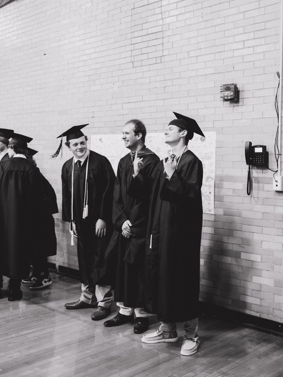 two students post with teacher after graduation