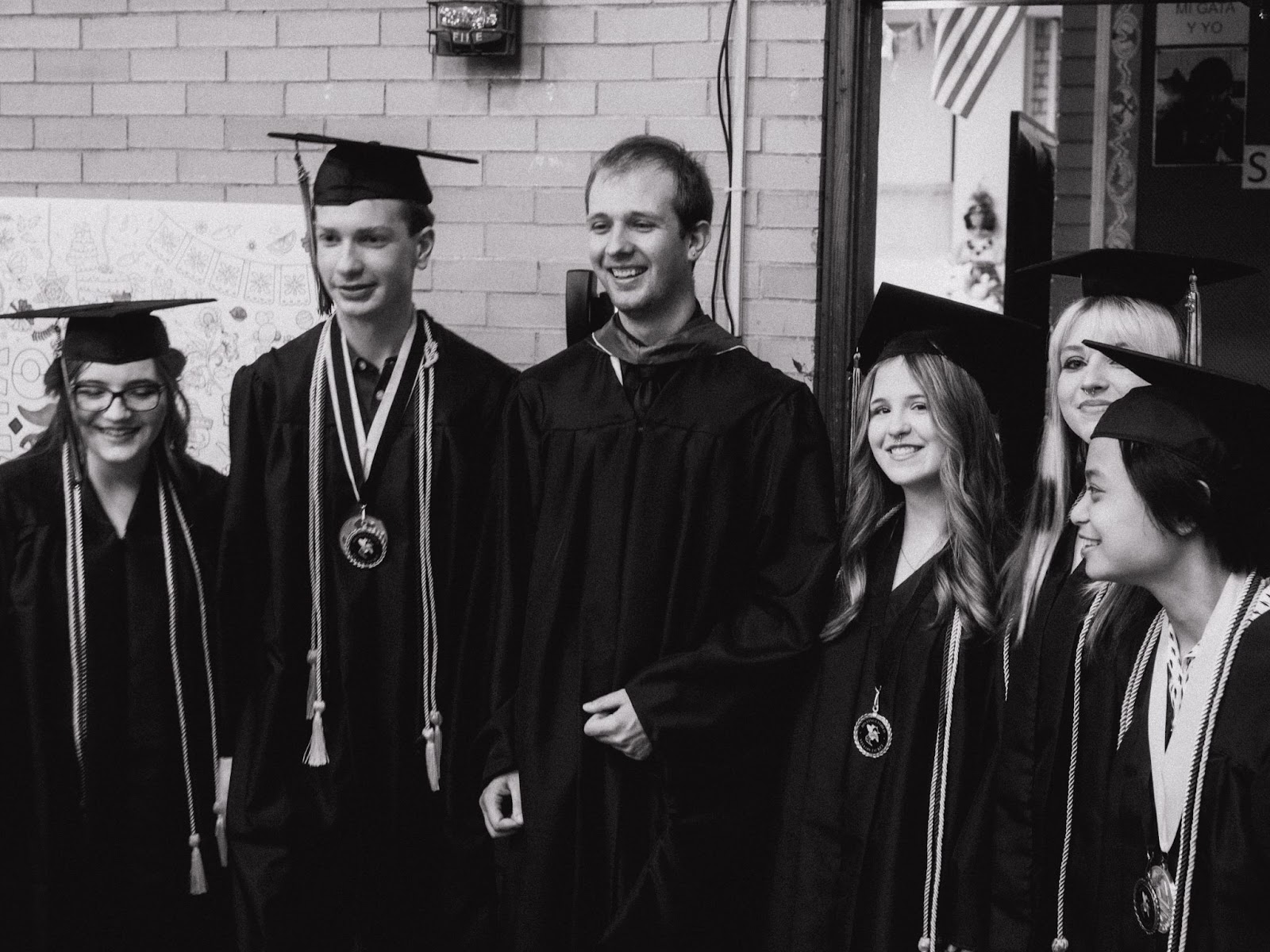 teacher and students pose for photo after graduation