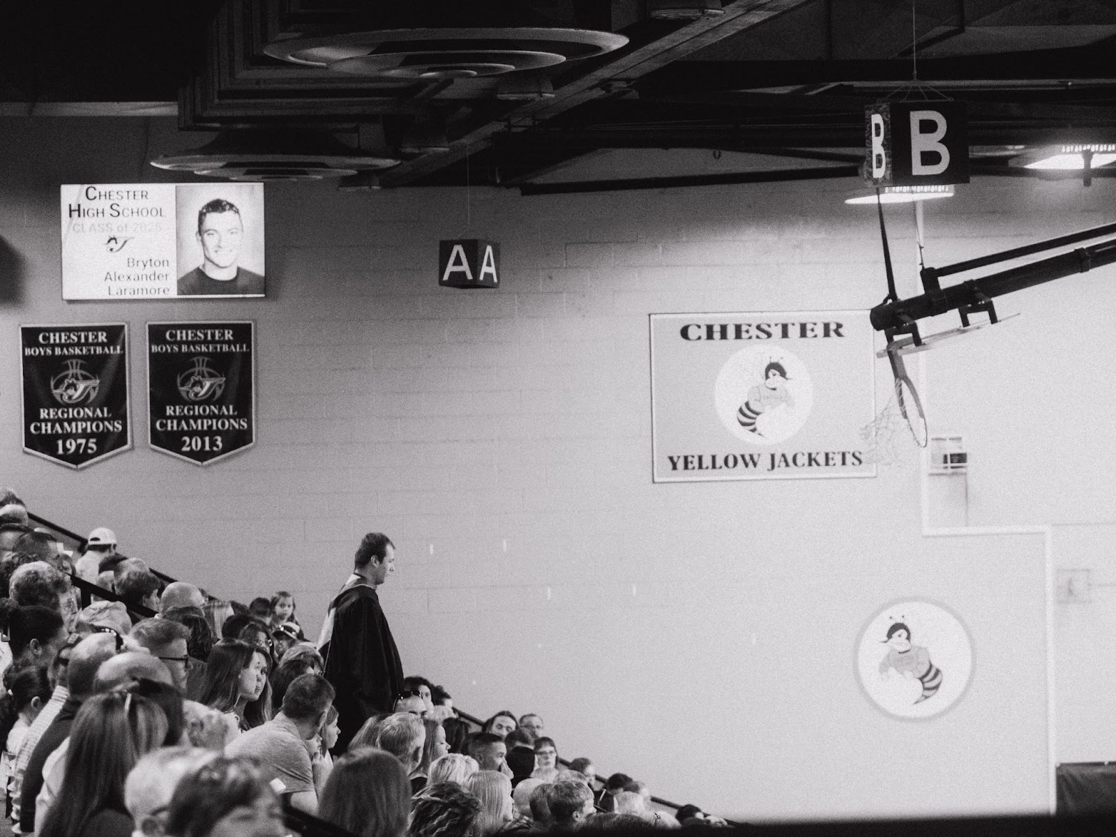 teacher walks down bleachers in crowded gym