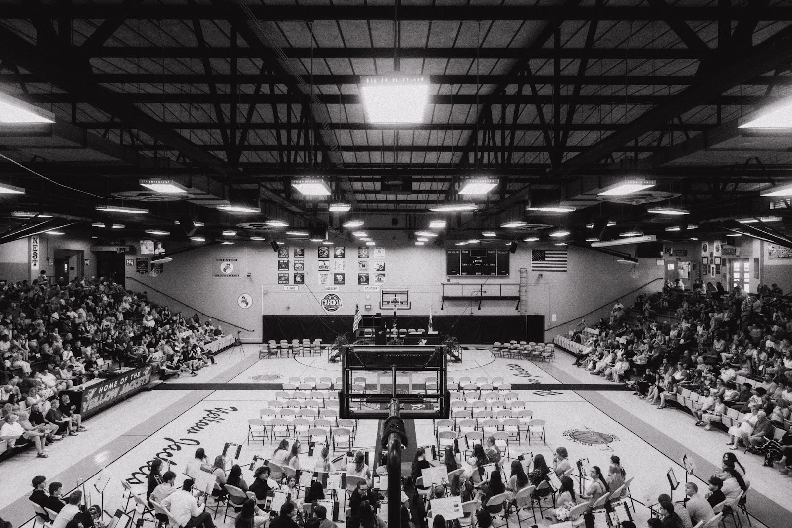 a crowded gym with people waiting for graducation ceremony