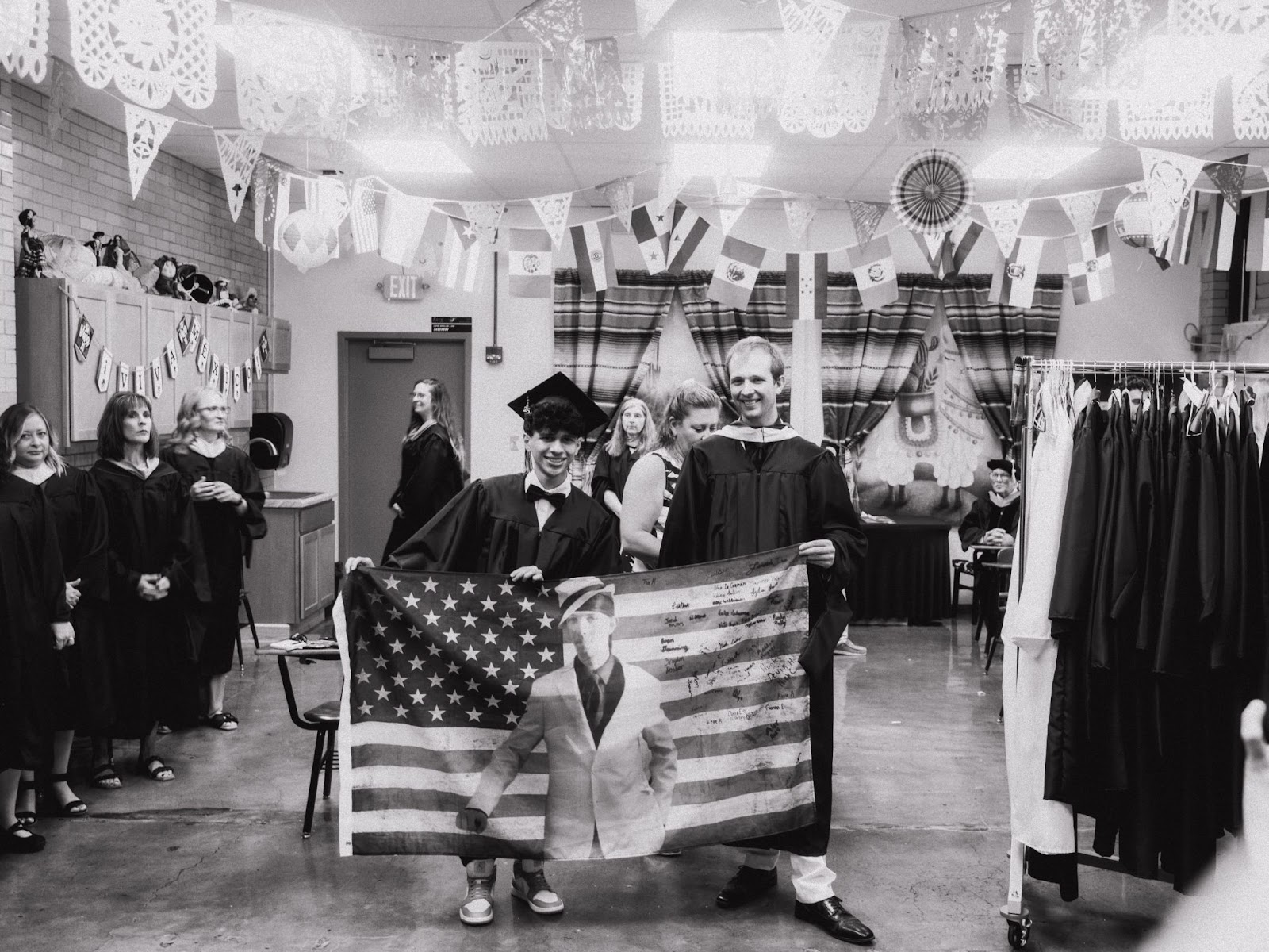 teacher poses with student gift of a flag