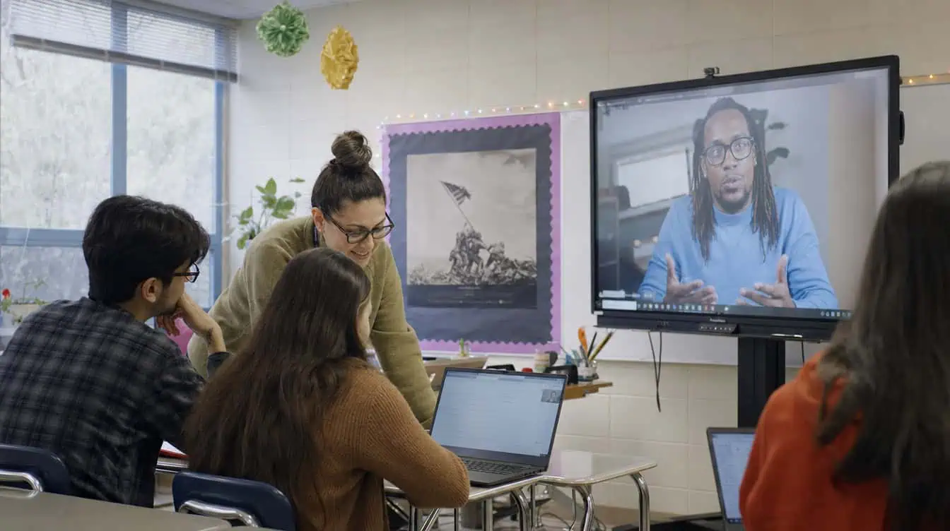 Teacher on video call teaching students in a classroom setting.